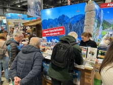 Prospektpräsentation am Messestand Urlaub in den Alpen