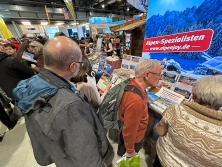 Prospektpräsentation am Messestand Urlaub in den Alpen