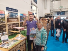 Prospektpräsentation am Messestand Urlaub in den Alpen