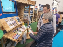 Prospektpräsentation am Messestand Urlaub in den Alpen