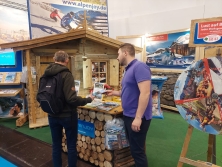 Prospektpräsentation am Messestand Urlaub in den Alpen