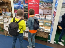 Prospektpräsentation am Messestand Urlaub in den Alpen