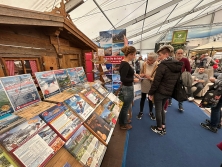 Prospektpräsentation am Messestand Urlaub in den Alpen