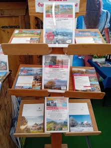 Prospektpräsentation am Messestand Urlaub in den Alpen
